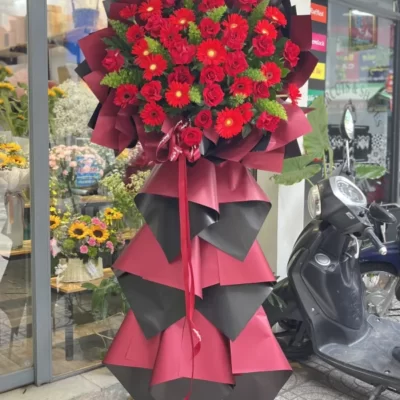 Kệ hoa chúc mừng khai trương tone đỏ rực rỡ : đồng tiền đỏ mix hồng đỏ ý nghĩa